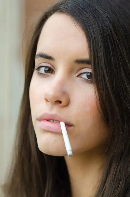 美丽的黑皮肤女孩抽烟的肖像