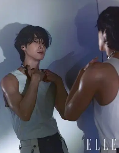 他身穿白色紧身背心,栗色皮肤肌肉紧实. 郑允浩手扶脸颊,眼神放电.