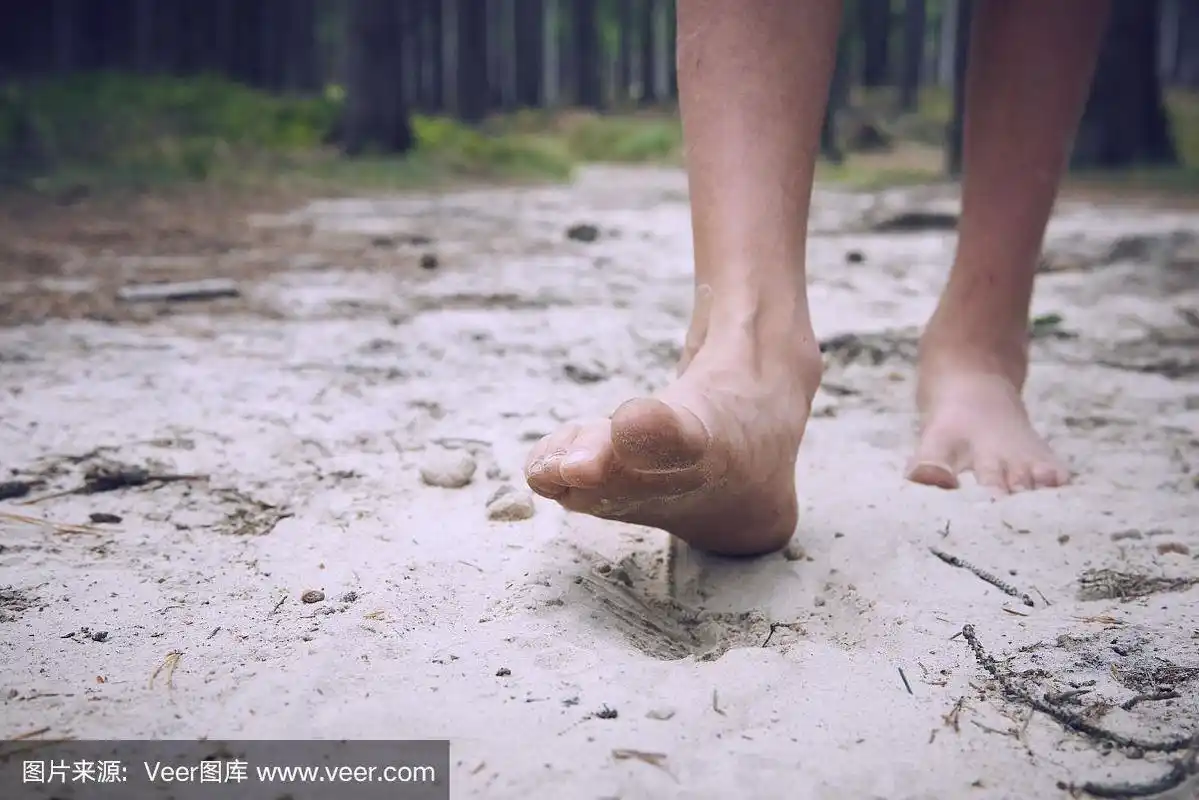 快乐赤脚的孩子独自走在小路上,探索森林.