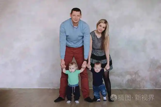 快乐的家庭portrair有两个男孩的双胞胎宝宝的父母