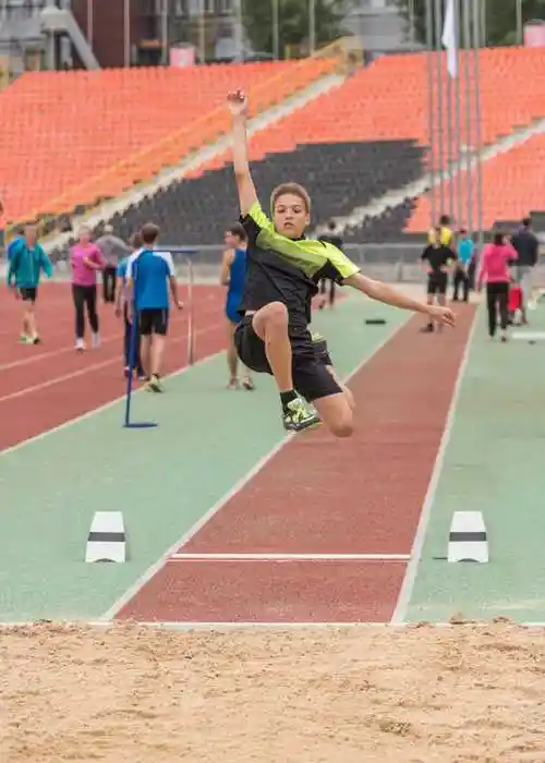 坐在沙坑上的跳远运动员
