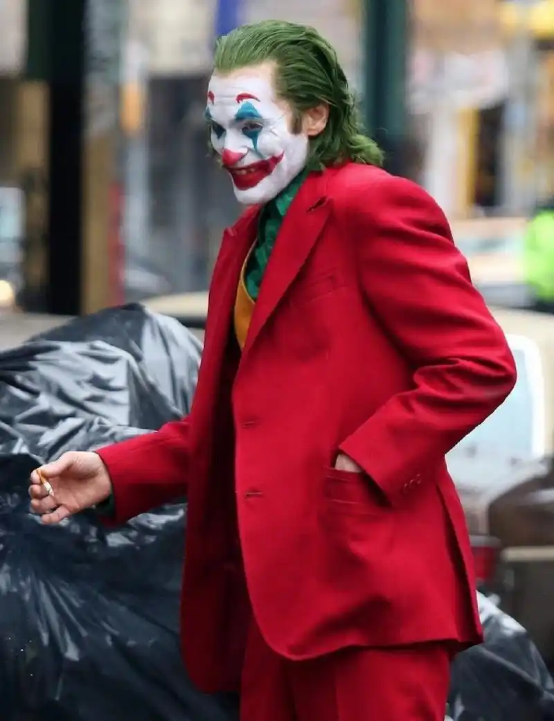 新版 《小丑》曝光全新片场照, 杰昆·菲尼克斯一身红色西装街头狂奔