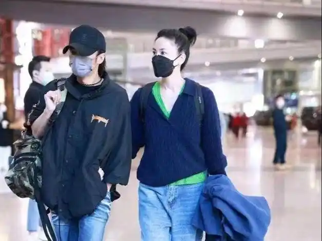 王菲牵谢霆锋走机场扎马尾像高中生小男友单手插兜扮酷