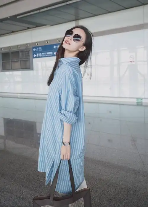 倪妮现身机场 条纹长衬衫搭白色小脚裤