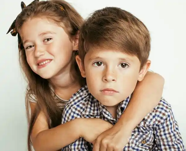 小可爱的男孩和女孩拥抱在白色背景上玩开心的家庭笑