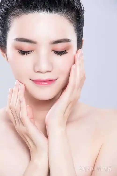 女人闭上眼睛触摸脸在灰色背景上有美容护肤的概念