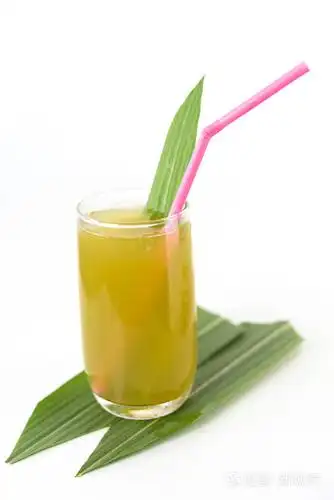 新鲜的甘蔗汁在白色背景上的玻璃