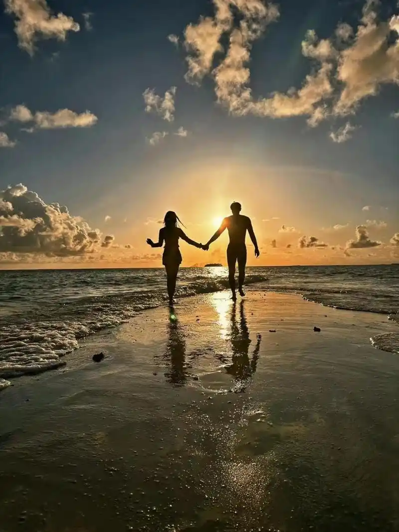 夕阳西下,一对情侣在海边散步,他们大声叫着:"日落海边,许个心愿".