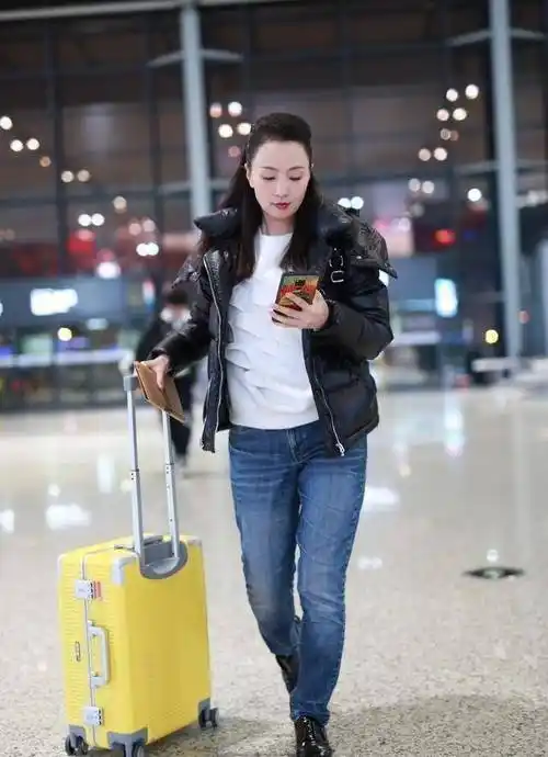 原创原创48岁陶虹浓妆走机场亮皮面包服搭白t保暖时髦歪头卖萌似少女