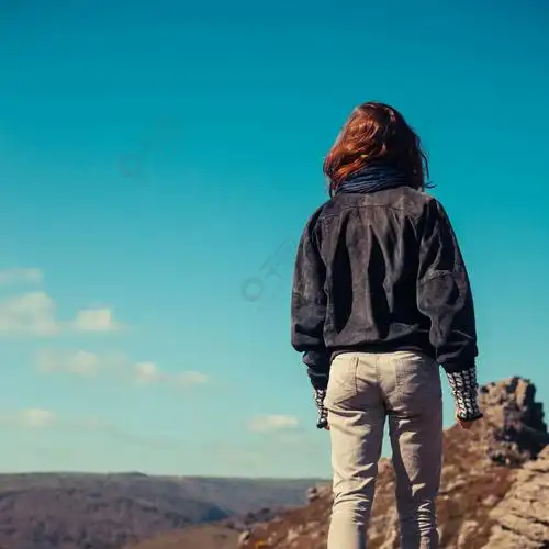 一个年轻女子在晴朗的一天在山上行走