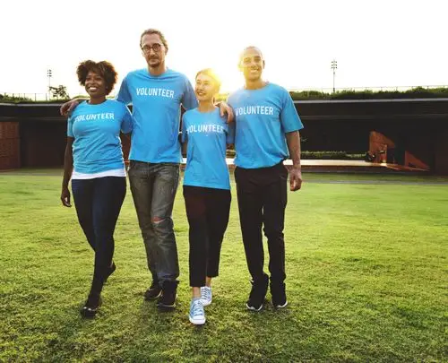 四个人走在绿草如茵的草地上