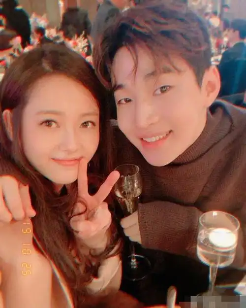 照片中,高雅拉穿着长裙,henry穿着毛衣,用手亲密地搂着高雅拉的肩膀