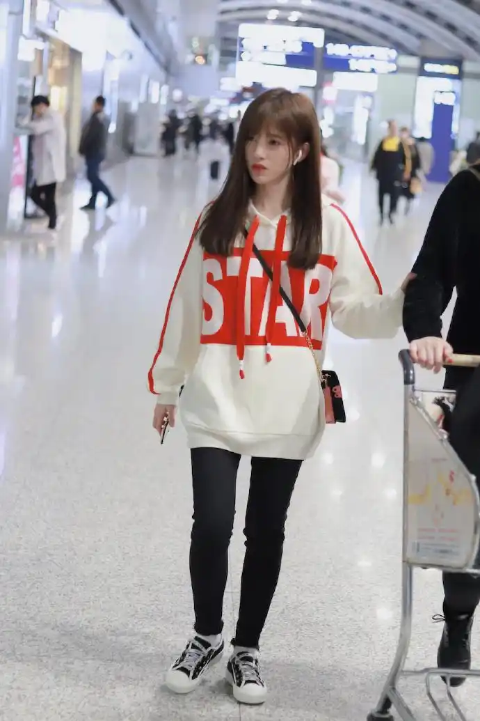鞠婧祎红唇穿白色卫衣搭配黑色紧身裤现身机场皮肤白皙