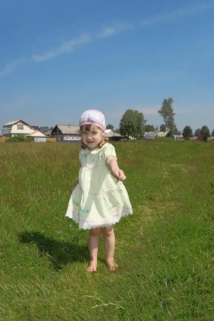 光着脚的小女孩扮演节目片草叶在绿色的草地上