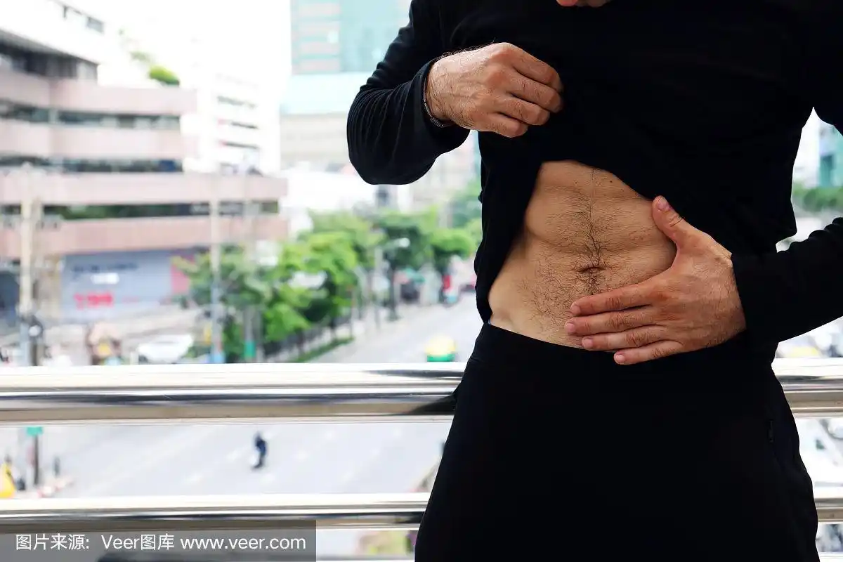 特写运动员在街上展示了六块腹肌.