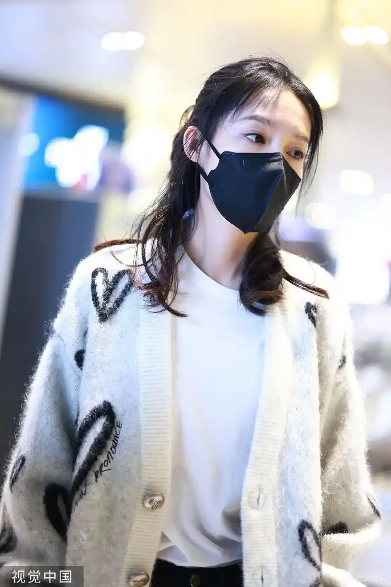 组图:李沁爱心花纹毛衣造型现身机场 长发披肩温柔