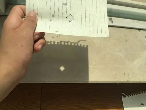 将刻有1cm棱形小孔的纸片放在阳光下,地面上形成的光斑为棱形