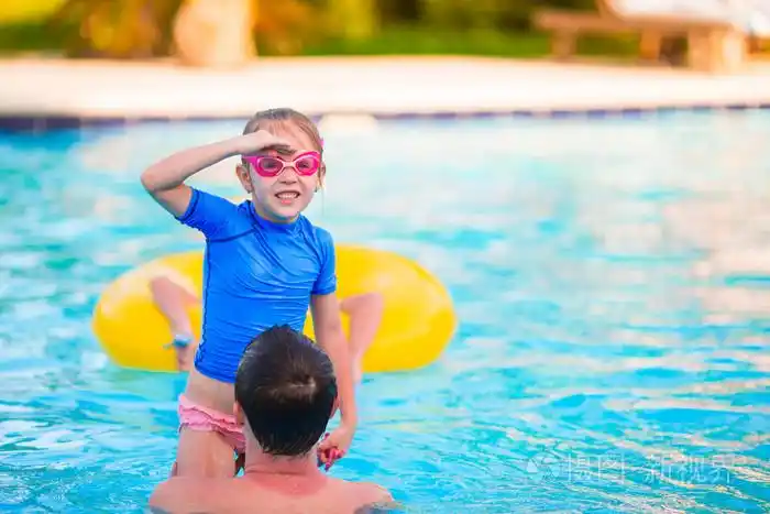 幸福的家庭在户外游泳池在一起开心