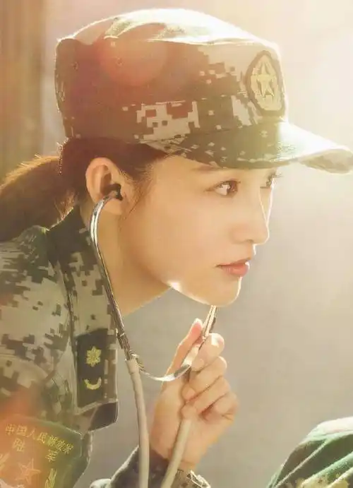 照片中,李沁身着军装,看着戴着助听器的黄景瑜.