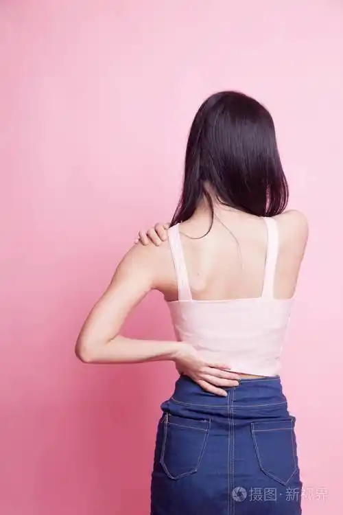 年轻的亚裔女性背部疼痛的粉红色背景