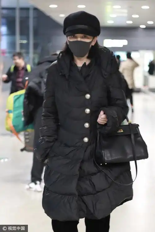 王琳 黑色羽绒大衣金丝绒阔腿裤 头戴报童帽低调简约