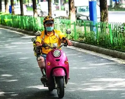 李栋骑着电动车送外卖.