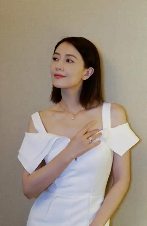 高圆圆穿白色礼服露香肩窗边拍照温婉动人