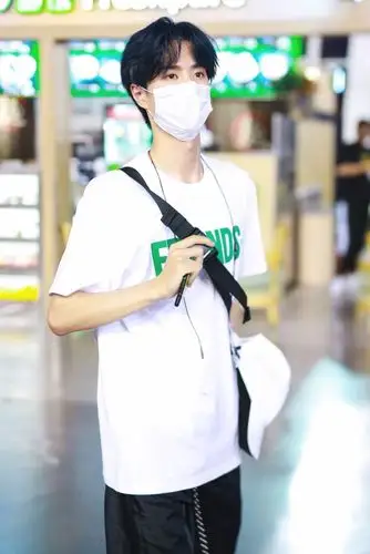 王一博穿白色字母t恤搭配黑色长裤现身 口罩遮面中分发型清爽帅气