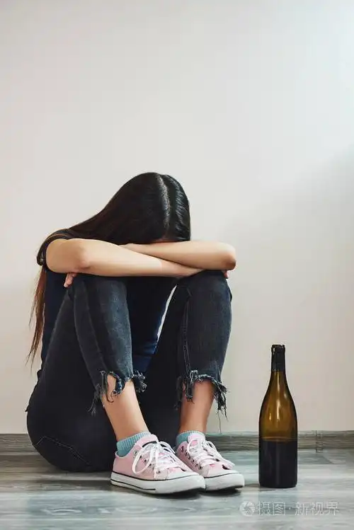 绝望的女人坐在空房间的地板上.女性酗酒观念.