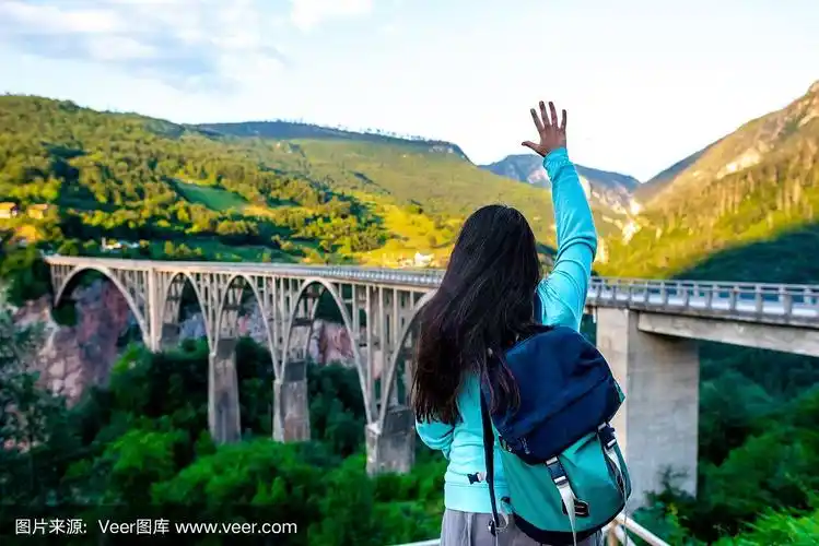 黑山妇女向混凝土拱桥挥手的背影