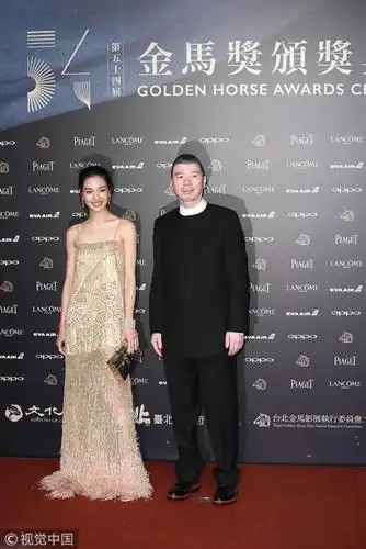 冯小刚携"刚女郎"钟楚曦黑白搭配 严肃亮相金马红毯