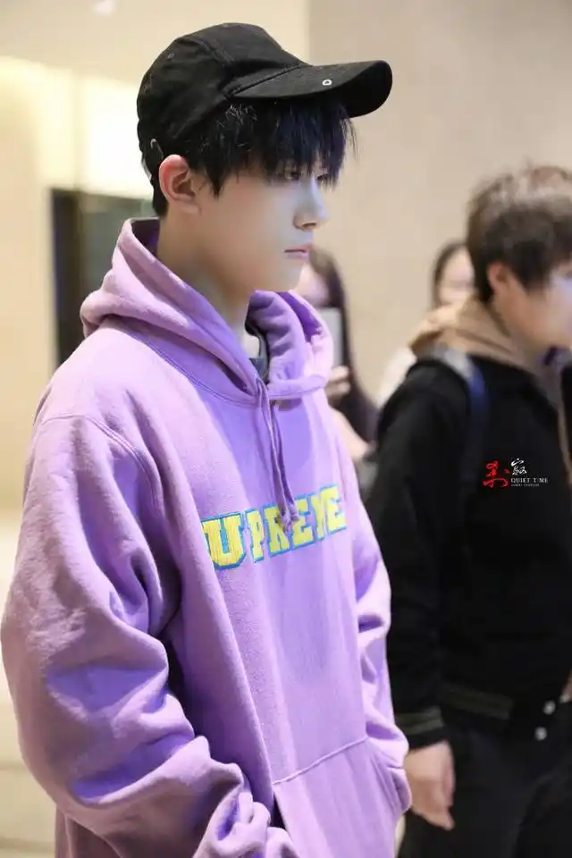 易烊千玺身着紫色卫衣,搭配黑色圆领t恤,穿着红色休闲裤,简直就是春季