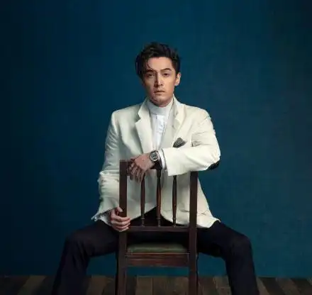 胡歌身穿咖色丝绒西装,发型一丝不苟,尽现雅痞绅士风度