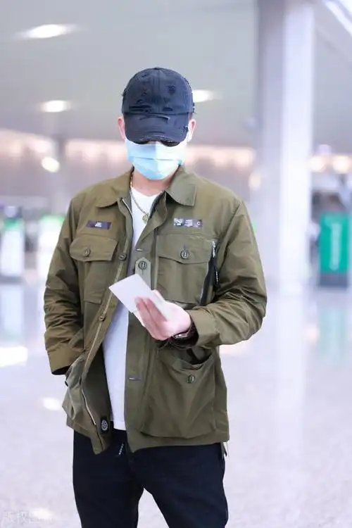 欧豪身穿军绿色外套仿佛特种兵,独自拎大包小裹赶行程