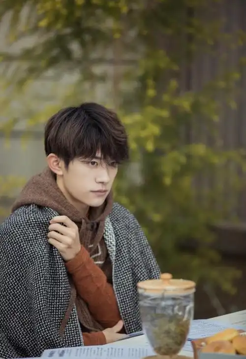 易烊千玺穿复古连帽马甲 专注聆听梨涡浅笑文艺范十足