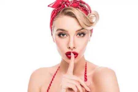 有吸引力的别针的肖像,女人做嘘手势,看着隔离在白色上的相机照片