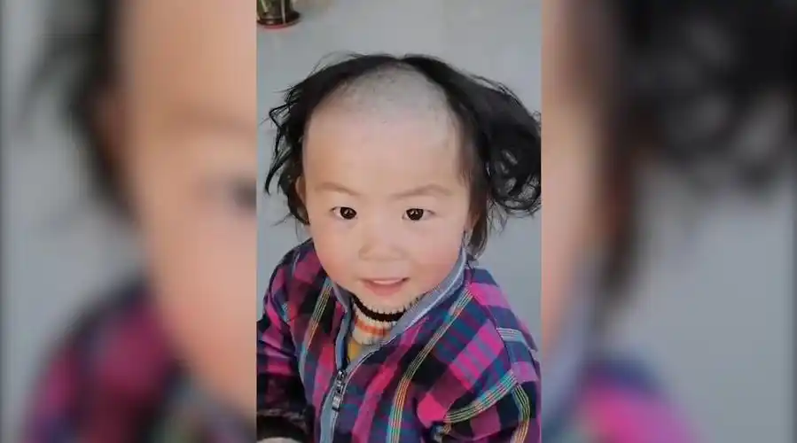 山东安丘的一个小女孩趁大人没注意为自己理发,将一半头发剃成光头,一