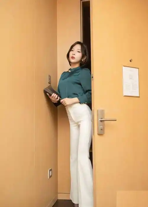 短发美女身着精致的墨绿色衬衫,与黑色高跟鞋相搭配,优雅干练_女性