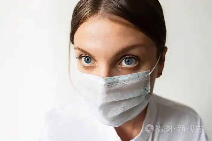 一名女护士戴上口罩以防止空气传播的呼吸道疾病如流感冠状病毒埃博拉