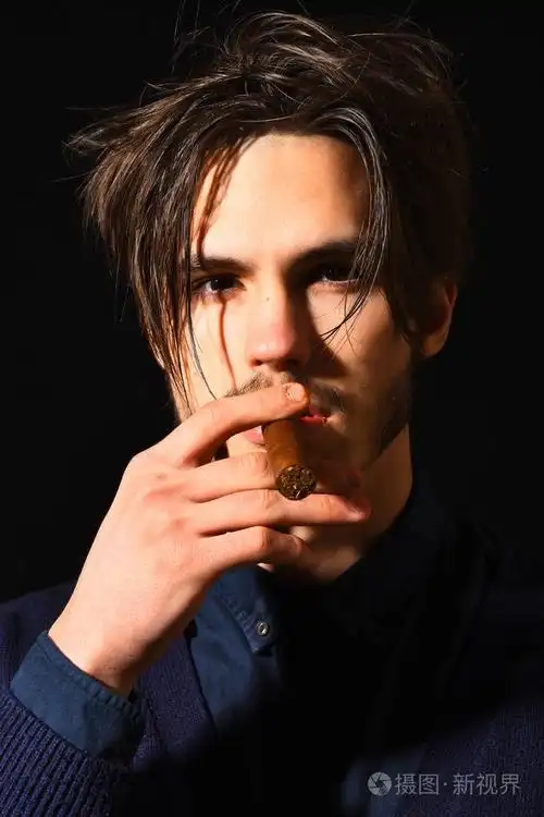 严重的大胡子的男人吸烟雪茄