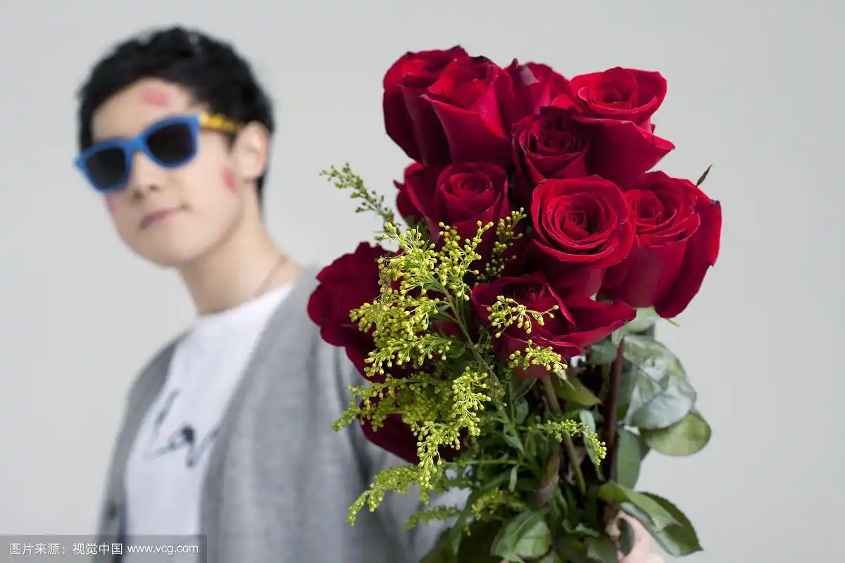 拿红玫瑰的亚洲男青年