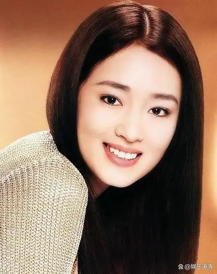 照片中展示了巩俐戴着黑色金属眼镜和贝雷帽,身穿宽松的浅黄色卫衣和