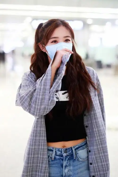 近日张含韵现身机场她穿着黑色印花t恤下身搭配着一条牛仔短裤外搭着