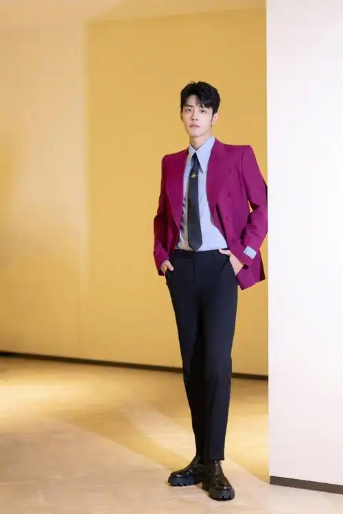 在红毯上的肖战一身红色西装黑色领带上的小蜜蜂点睛