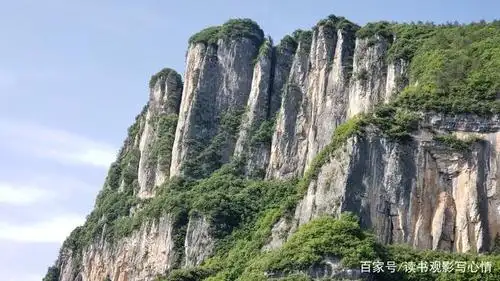 绿色的植被点缀在陡峭的峭壁之间,给巍峨的大山平添了几分柔美.