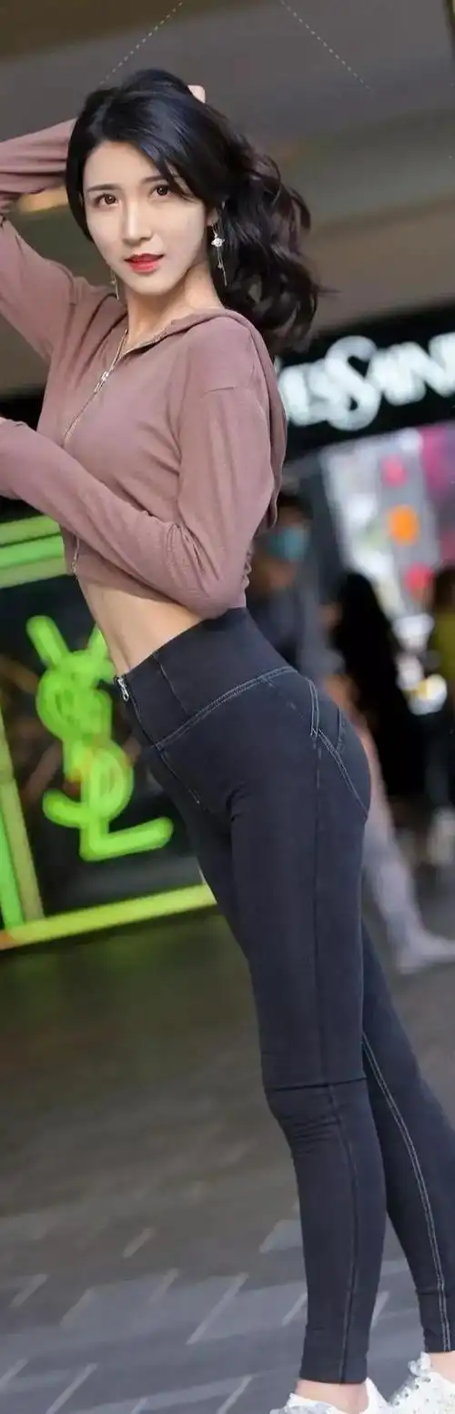 灰紧牛仔裤和粗跟高跟鞋苗条的女孩穿着很有自信