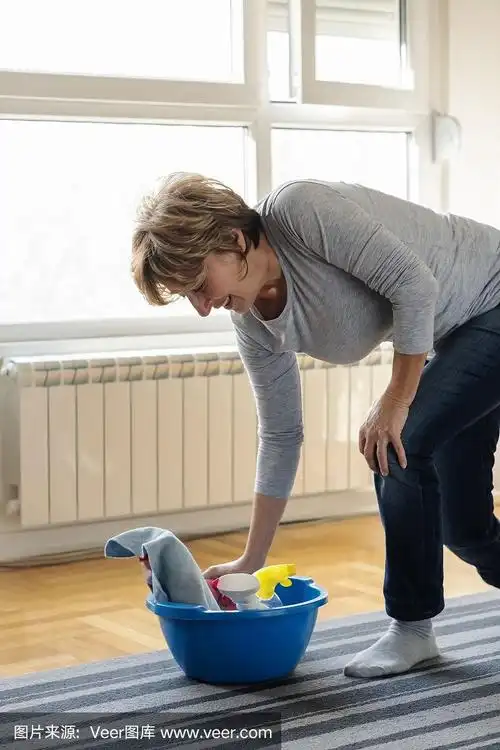 老妇人在家打扫灰尘