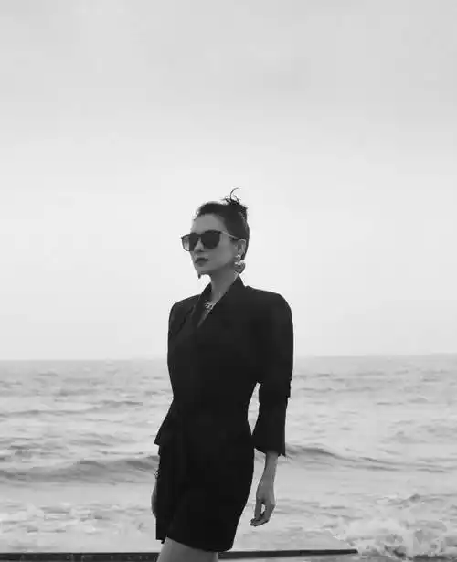 章子怡戴墨镜,侧颜线条精致. 章子怡打伞远眺.