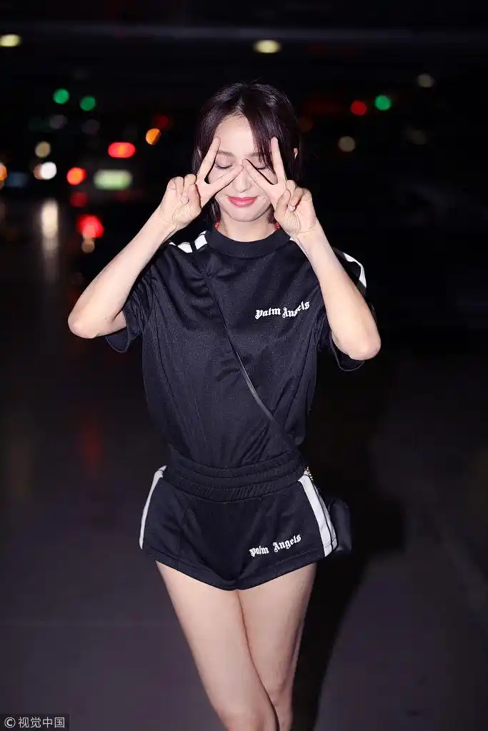 热心佟市民!佟丽娅机场扶提示牌 运动短裤秀美腿花式比心