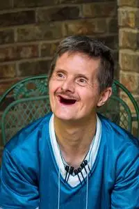 他脸上的喜悦表明他没有牙齿了.他衬衫上的标记表明他收集钢笔.照片